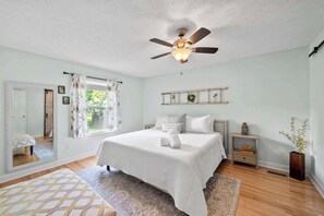The serene first bedroom retreat features a plush king bed