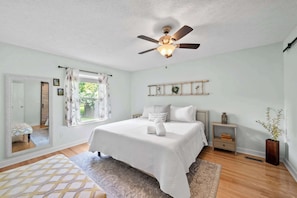 The serene first bedroom retreat features a plush king bed