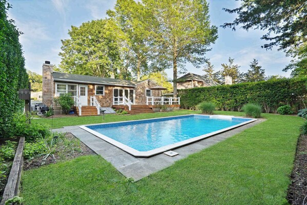 Backyard pool surrounded by trees