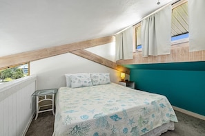 The loft bedroom sits above the ktichen and looks over the living room