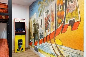 Arcade game with multiple games and custom wall mural.