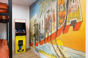 Arcade game with multiple games and custom wall mural.