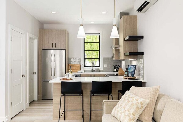 Experience culinary delight in this bright, open kitchen, fully stocked with modern appliances and sleek finishes.