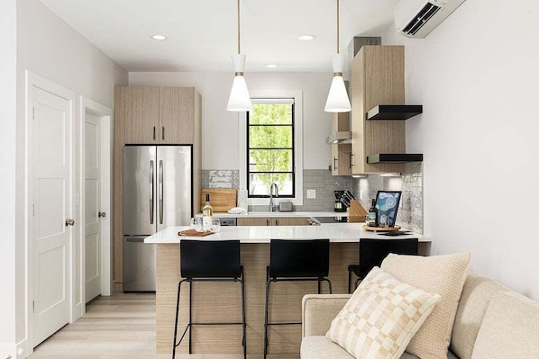 Experience culinary delight in this bright, open kitchen, fully stocked with modern appliances and sleek finishes.