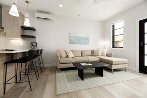 Modern comfort meets minimalist charm in this airy living space with a plush sectional and smart entertainment setup.