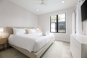 Spacious and stylish, this king bedroom offers comfort and convenience with a large window, open closet, and cozy linens.