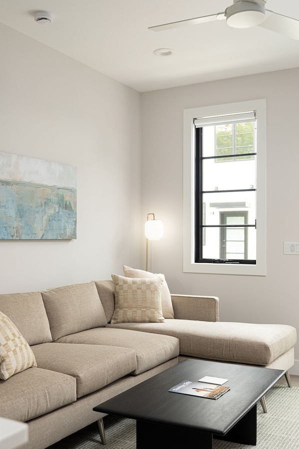 Unwind in a bright and inviting living room with a spacious layout, soft seating, and a calming neutral palette.