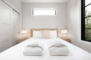 Relax in this bright and inviting queen bedroom, complete with a spacious closet and serene, minimalist décor.