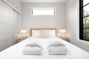 Relax in this bright and inviting queen bedroom, complete with a spacious closet and serene, minimalist décor.