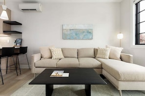 Kick back in this contemporary lounge area with a comfy sectional, smart TV, and warm, welcoming vibes.