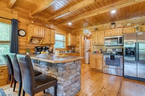 Spacious kitchen with wood cabinetry and stainless steel appliances.