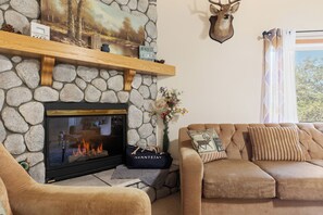 The living room features a fireplace and a comfortable sofa.