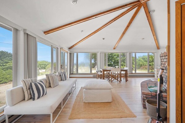 Bright sunroom with vaulted ceiling and nature views
