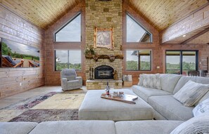 Great room, large sofa, fire place and 85" TV