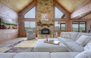 Great room, large sofa, fire place and 85" TV