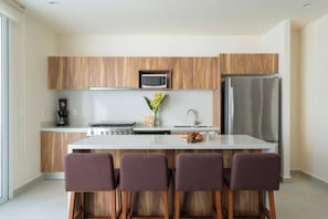 Elevate your culinary experience in our well-equipped kitchen, which includes modern amenities such as a dishwasher microwave, blender, toaster, coffee maker, and a six-burner stove with an oven.