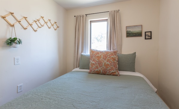 Simple and serene bedroom with soft tones and a touch of charm