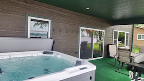 Outdoor covered dining area with gas grill and a 6 person jacuzzi with a view.
