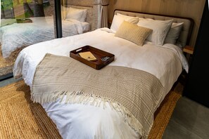 Wake up wrapped in comfort with nature just beyond the glass—our plush queen bed is made for slow mornings and starry nights.