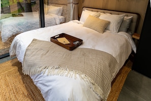 Wake up wrapped in comfort with nature just beyond the glass—our plush queen bed is made for slow mornings and starry nights.