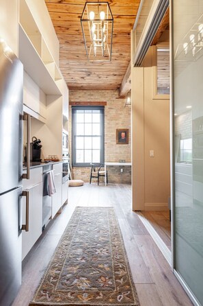 Timeless exposed‑brick walls and sleek full kitchen shine in this Stratford Ontario loft, steps from Downie Street’s heritage core.