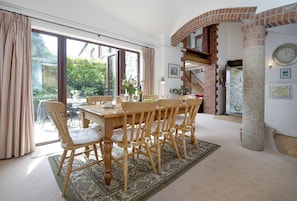 The Linhay, Noss Mayo. Ground Floor: Open-plan kitchen and dining area, with high ceilings, exposed brickwork and concrete pillars