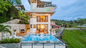 Casa Vistas Infinitas at sunset—sleek lines glowing against the jungle.
