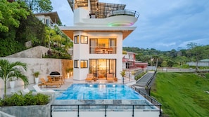 Casa Vistas Infinitas at sunset—sleek lines glowing against the jungle.