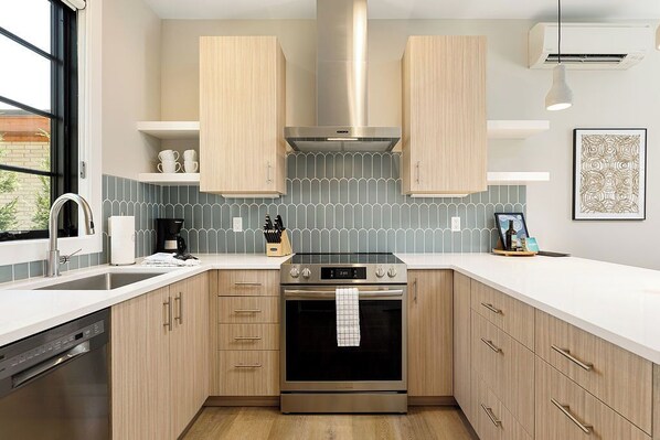 Step into a fully equipped kitchen featuring modern stainless steel appliances, sleek cabinetry, and a stylish backsplash. With spacious countertops, it's a dream space for any cooking enthusiast.