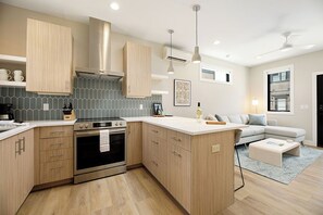 This beautifully designed kitchen comes fully equipped with everything you need. From the modern stainless steel stove to the ample storage and chic backsplash, it's both functional and stylish.