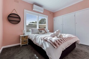 Bedroom 2 with queen bed, split system air-conditioner and ample storage. 