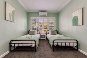 Bedroom 3 with 2 x king single beds, split system air-conditioner and ample storage.