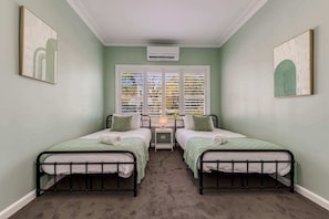 Bedroom 3 with 2 x king single beds, split system air-conditioner and ample storage.