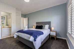 Main bedroom with queen bed, split system air-conditioner and small ensuite with toilet and basin. 