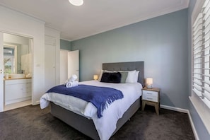 Main bedroom with queen bed, split system air-conditioner and small ensuite with toilet and basin.