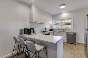 Fully-equipped kitchen with stove, oven, toaster, kettle, dishwasher, pod coffee machine and more. 