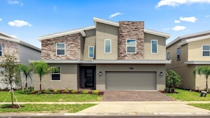 Modern two-story home with a spacious driveway and lush landscaping
