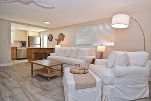 A large open floor plan with a table for 6 and a queen sleeper sofa