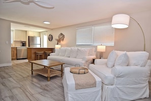 A large open floor plan with a table for 6 and a queen sleeper sofa