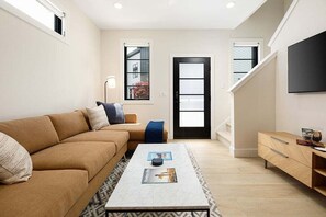 Modern comfort meets entertainment—unwind on the plush sectional with smart TV access.