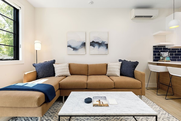 Stylish and functional—this living room offers a smart TV, comfy seating, and natural light.