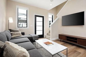 Relax in this modern living room with a cozy sectional, stylish decor, and natural light.