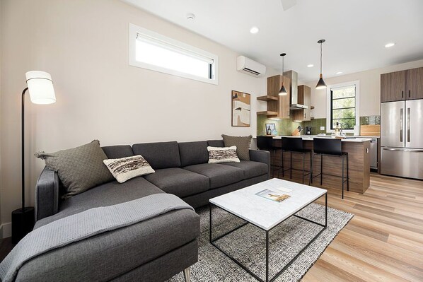 Comfort meets design in this bright living space featuring a marble coffee table and abstract art.