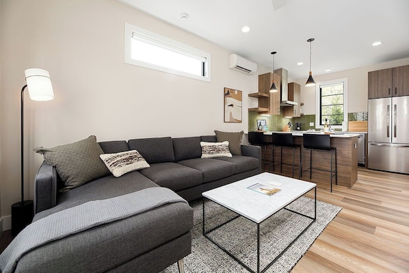 Comfort meets design in this bright living space featuring a marble coffee table and abstract art.