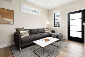 Unwind in this inviting living room with soft seating, warm wood floors, and contemporary touches.