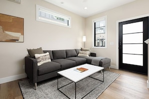 Unwind in this inviting living room with soft seating, warm wood floors, and contemporary touches.