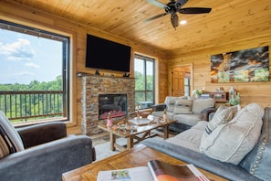 Living room with comfy seating, a warm fireplace, and a TV—perfect for relaxing after a day of adventure.
