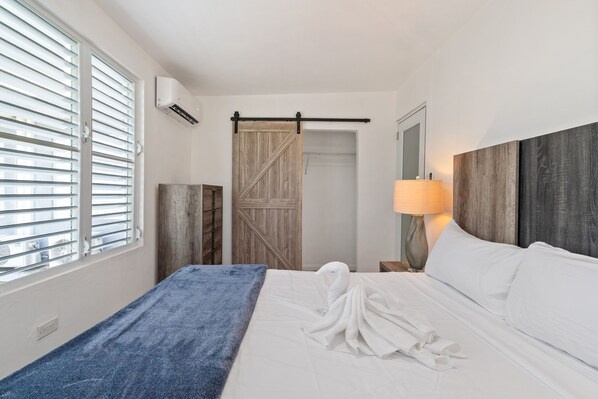 Serene bedroom with a comfortable king-size bed and charming barn door closet.
