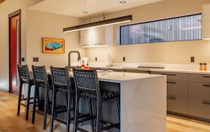 Sleek galley style kitchen with breakfast bar is thoughtfully planned to make preparing meals a pleasure.