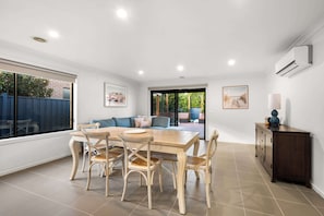 Open plan dining/seating area with direct access to the kitchen and backyard.